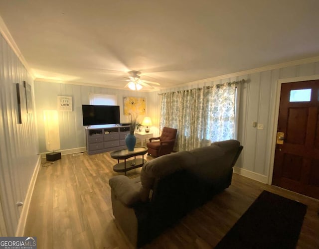 living room with hardwood / wood-style flooring, crown molding, and ceiling fan