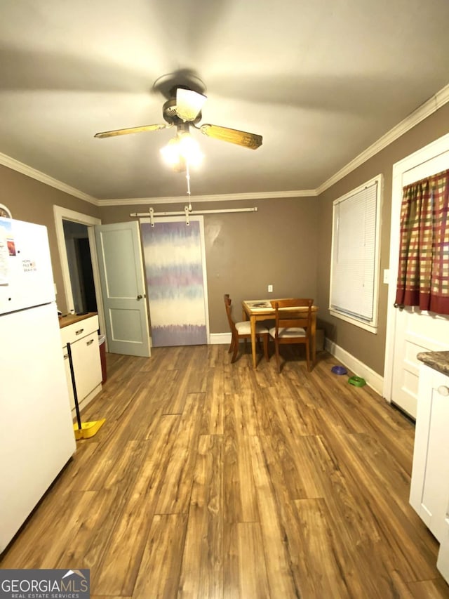 dining room with ornamental molding, hardwood / wood-style floors, and ceiling fan