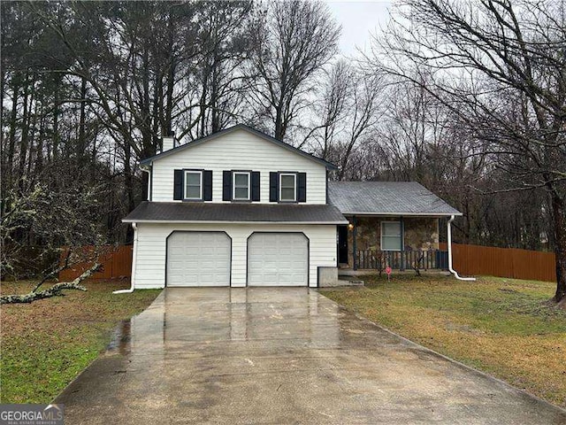 split level home featuring a garage, a front yard, and covered porch