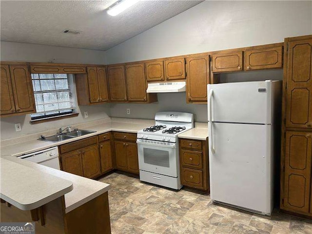 kitchen featuring sink, vaulted ceiling, a textured ceiling, kitchen peninsula, and white appliances