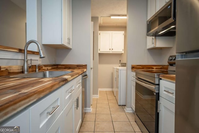 100 Downing Way Unit E, Athens, GA 30606 - kitchen with appliances with stainless steel finishes, butcher block countertops, sink, white cabinets, and washing machine and clothes dryer
