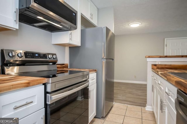 100 Downing Way Unit E, Athens, GA 30606 - kitchen featuring light tile patterned flooring, wooden counters, white cabinets, and appliances with stainless steel finishes
