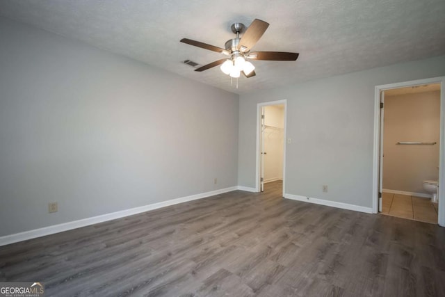 100 Downing Way Unit E, Athens, GA 30606 - unfurnished bedroom with connected bathroom, a walk in closet, wood-type flooring, a textured ceiling, and ceiling fan