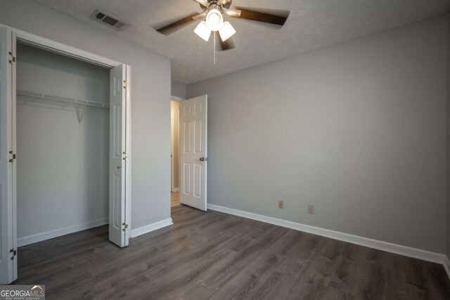 100 Downing Way Unit E, Athens, GA 30606 - unfurnished bedroom featuring dark wood-type flooring, a textured ceiling, and a closet