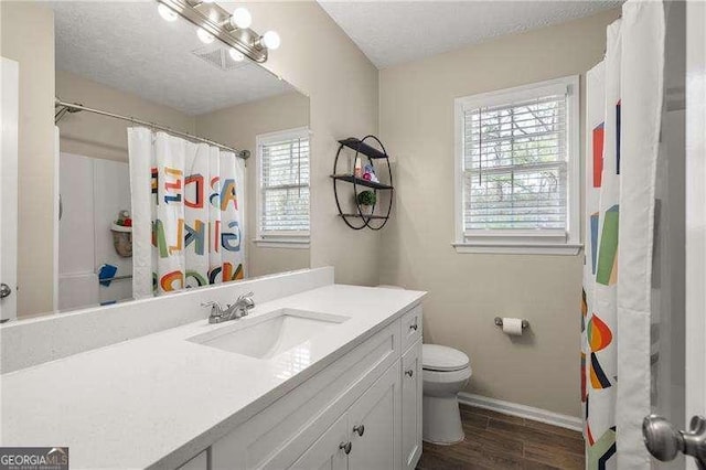 bathroom with vanity, hardwood / wood-style floors, a textured ceiling, and toilet