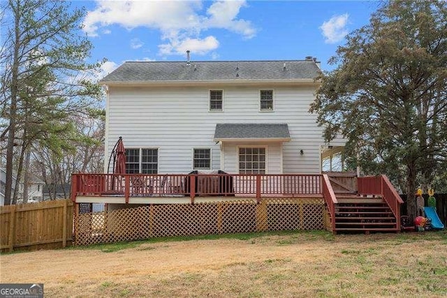 rear view of property with a yard and a deck