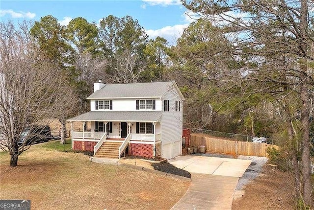 view of front facade featuring a porch, a garage, and a front lawn