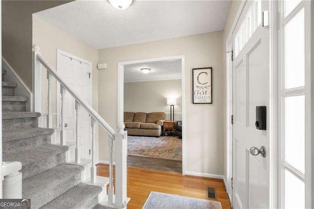 foyer entrance featuring hardwood / wood-style floors and a textured ceiling