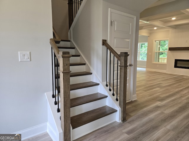 508 Clayborne Way Unit 246A, Loganville, GA 30052 - stairs featuring wood finished floors, baseboards, coffered ceiling, beamed ceiling, and a glass covered fireplace