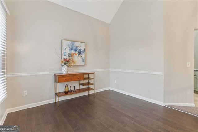 interior space featuring lofted ceiling and dark hardwood / wood-style flooring