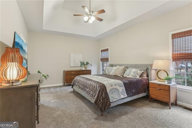 bedroom featuring carpet floors, a raised ceiling, and ceiling fan