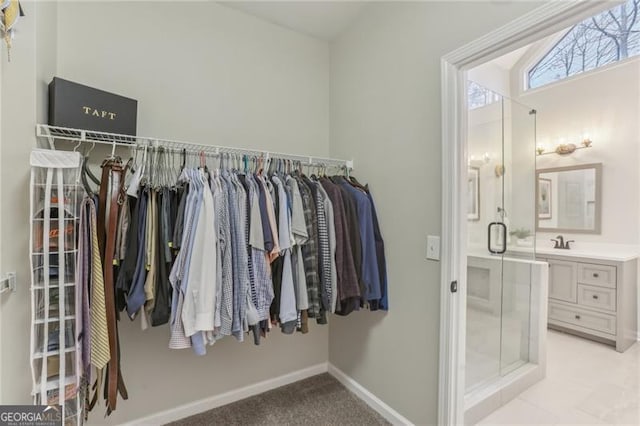 walk in closet with light carpet and sink