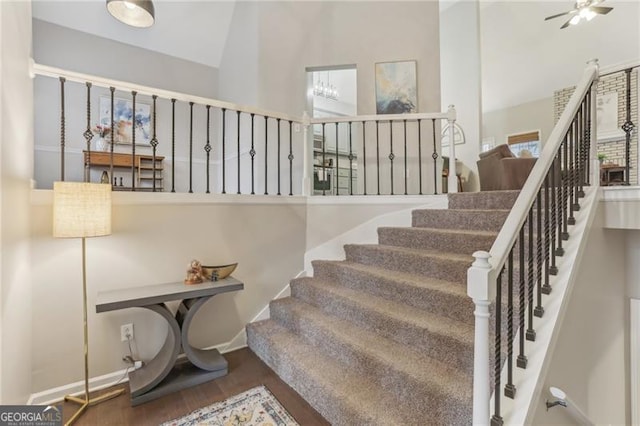 stairs featuring hardwood / wood-style floors and ceiling fan