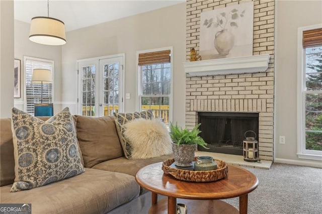 living room with a fireplace, a wealth of natural light, carpet floors, and french doors