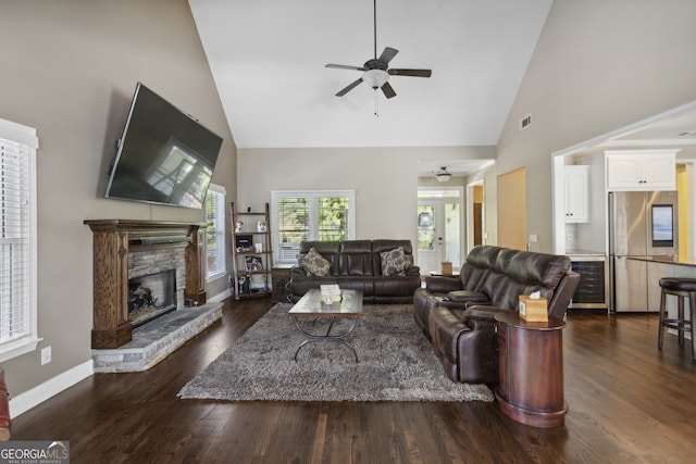 living room with a fireplace, dark wood-type flooring, high vaulted ceiling, and ceiling fan