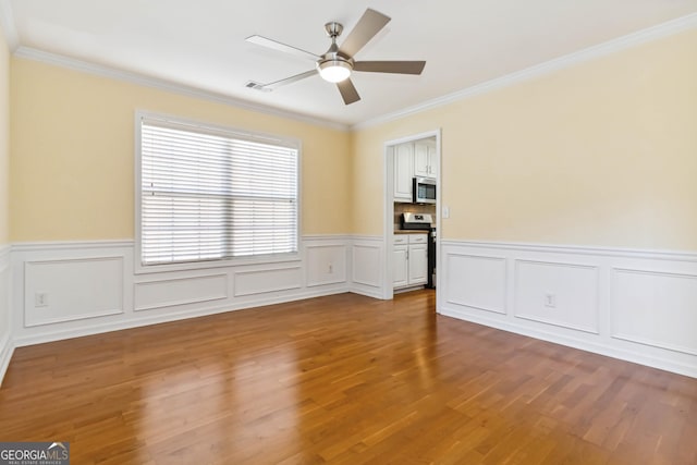 480 Glenns Farm Way, Grayson, GA 30017 - spare room featuring crown molding, ceiling fan, wood finished floors, and wainscoting