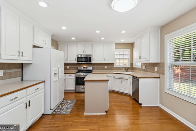 480 Glenns Farm Way, Grayson, GA 30017 - kitchen featuring appliances with stainless steel finishes, decorative backsplash, a sink, white cabinetry, and recessed lighting