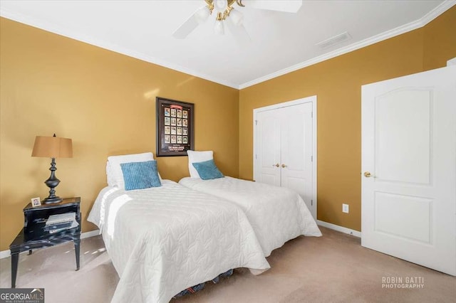 bedroom featuring ceiling fan, light colored carpet, ornamental molding, and a closet