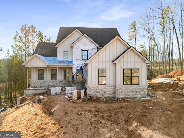 view of front facade featuring brick siding and board and batten siding