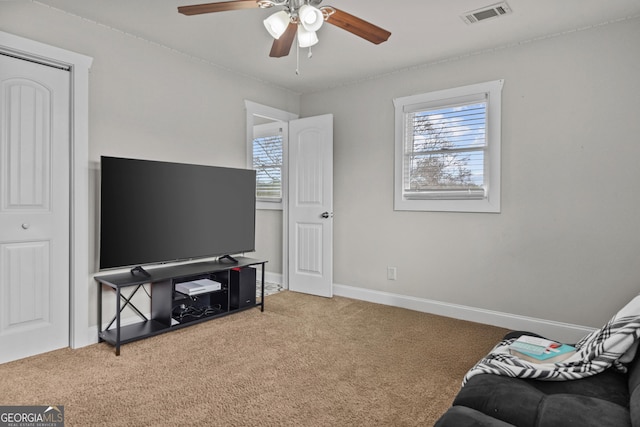 sitting room featuring carpet, a healthy amount of sunlight, and ceiling fan