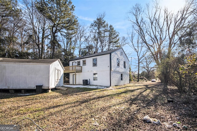 rear view of property featuring cooling unit, a yard, and a wooden deck