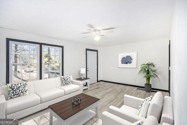 living room featuring ceiling fan and light hardwood / wood-style floors