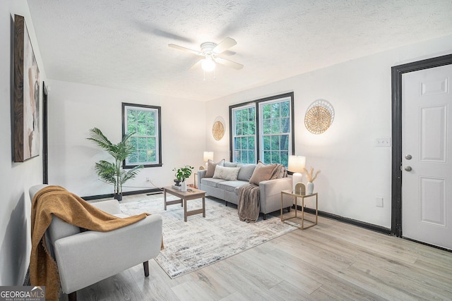 1490 Broad St NE, Conyers, GA 30012 - living room featuring light wood-style flooring, healthy amount of natural light, a ceiling fan, and a textured ceiling