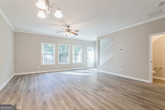 empty room featuring crown molding, ceiling fan with notable chandelier, and light wood-type flooring