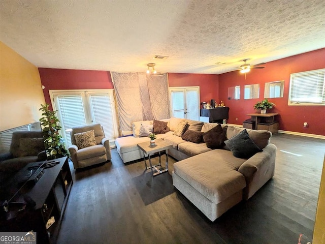 living room featuring dark hardwood / wood-style flooring, plenty of natural light, and a textured ceiling