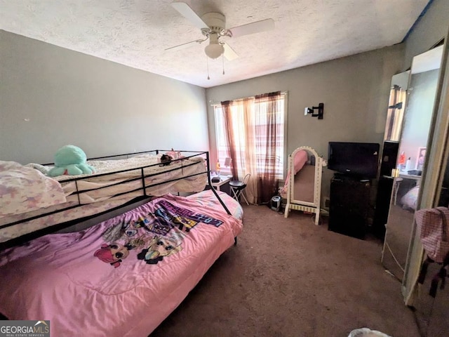 carpeted bedroom featuring ceiling fan and a textured ceiling