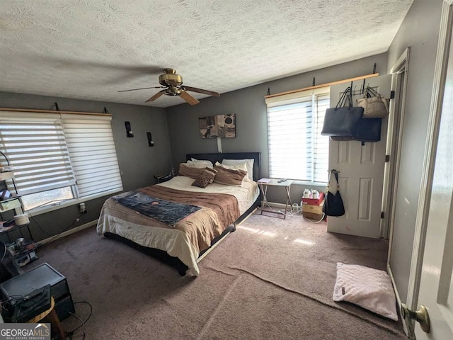 carpeted bedroom featuring a textured ceiling and ceiling fan