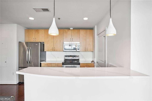 kitchen featuring stainless steel appliances, dark hardwood / wood-style flooring, kitchen peninsula, and hanging light fixtures