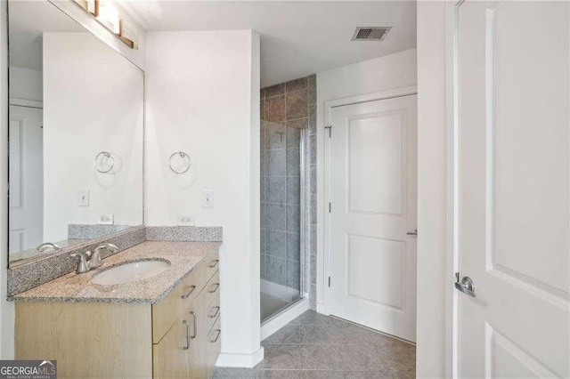 bathroom with an enclosed shower, vanity, and tile patterned floors