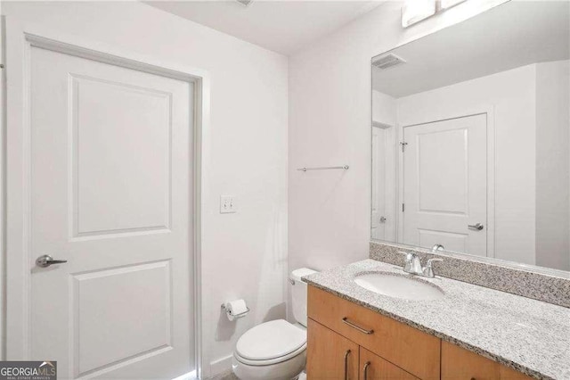 bathroom featuring vanity and toilet