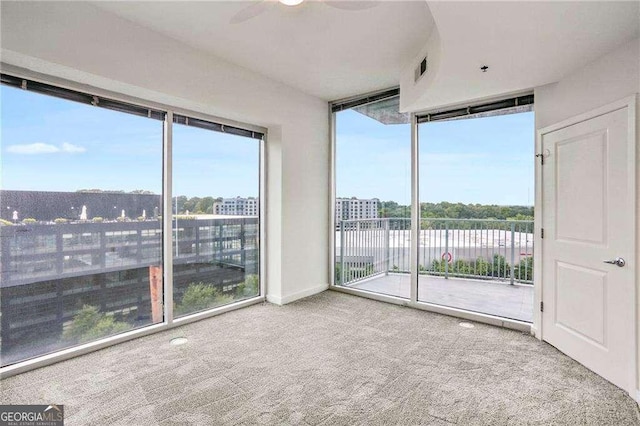 interior space with ceiling fan and a wall of windows