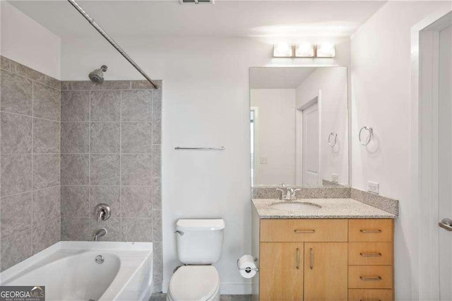 full bathroom featuring vanity, tiled shower / bath combo, and toilet