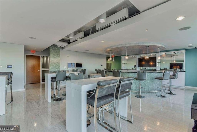 dining room with a community bar, baseboards, and recessed lighting