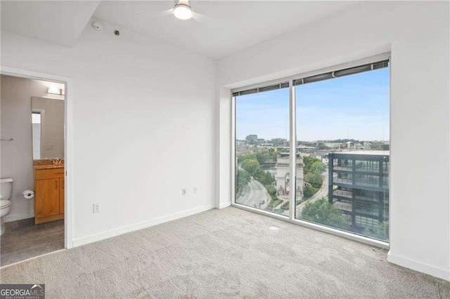 unfurnished bedroom featuring baseboards, carpet flooring, and a city view