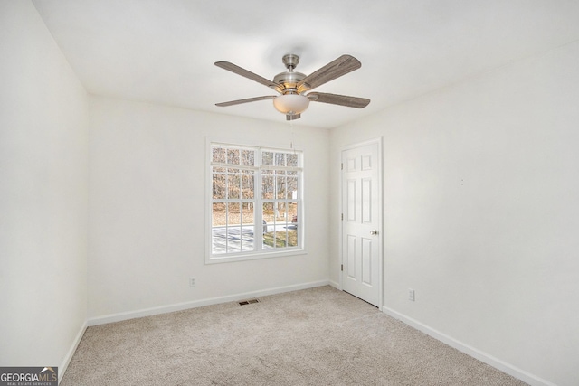 spare room featuring light carpet, baseboards, visible vents, and ceiling fan