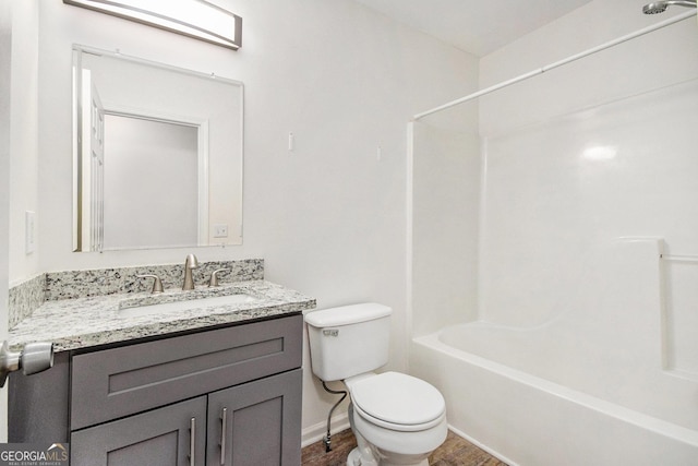 bathroom featuring toilet, baseboards, tub / shower combination, and vanity