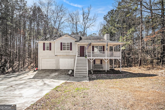 view of front of property featuring driveway, a garage, a chimney, stairway, and a porch