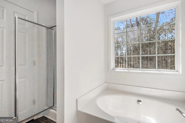 bathroom featuring a bath and a shower with shower door