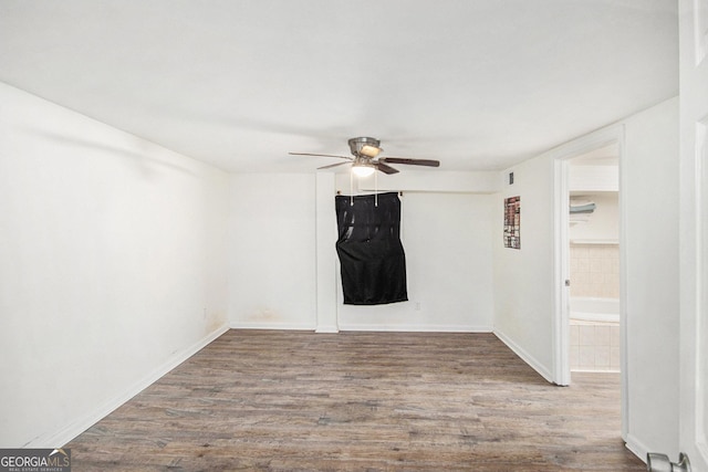 empty room featuring ceiling fan, wood finished floors, and baseboards