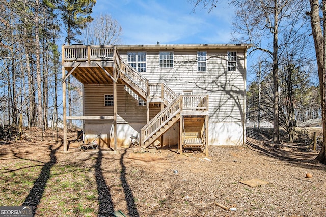 rear view of house featuring a deck and stairs