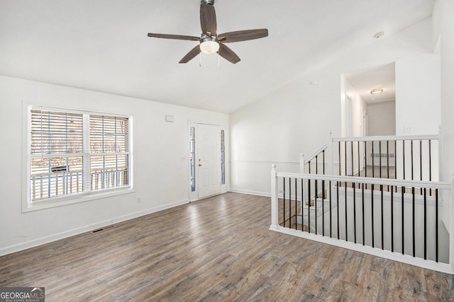 empty room featuring baseboards, visible vents, lofted ceiling, ceiling fan, and wood finished floors