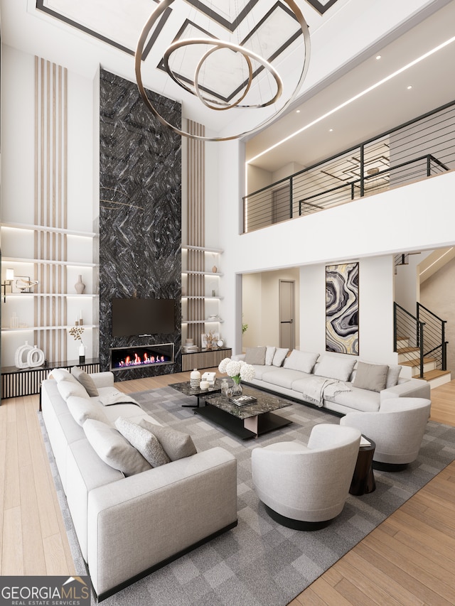 living room featuring a high ceiling, hardwood / wood-style floors, and a high end fireplace