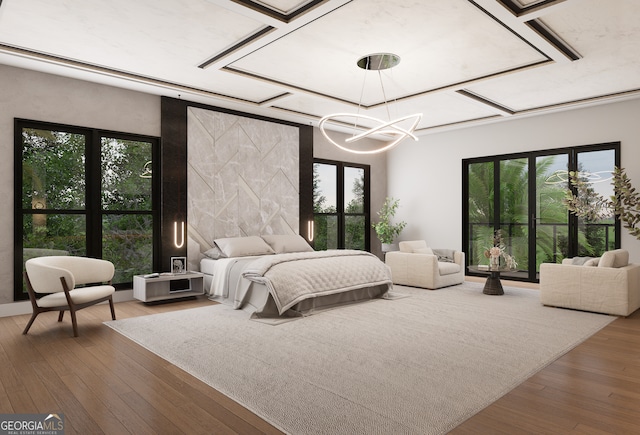 bedroom featuring hardwood / wood-style flooring, a notable chandelier, and multiple windows