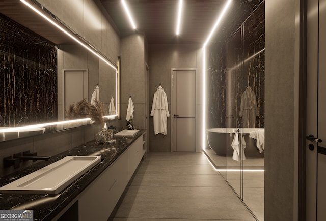 bathroom featuring vanity, a tub to relax in, and tile patterned flooring