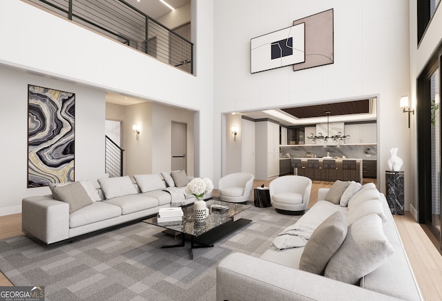 living room with a towering ceiling and light hardwood / wood-style flooring