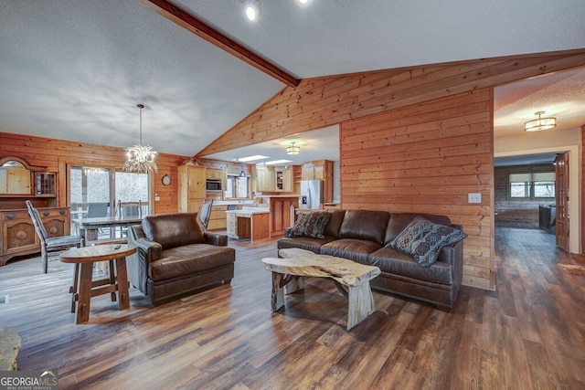 living room with dark hardwood / wood-style floors, wooden walls, a textured ceiling, and vaulted ceiling with beams